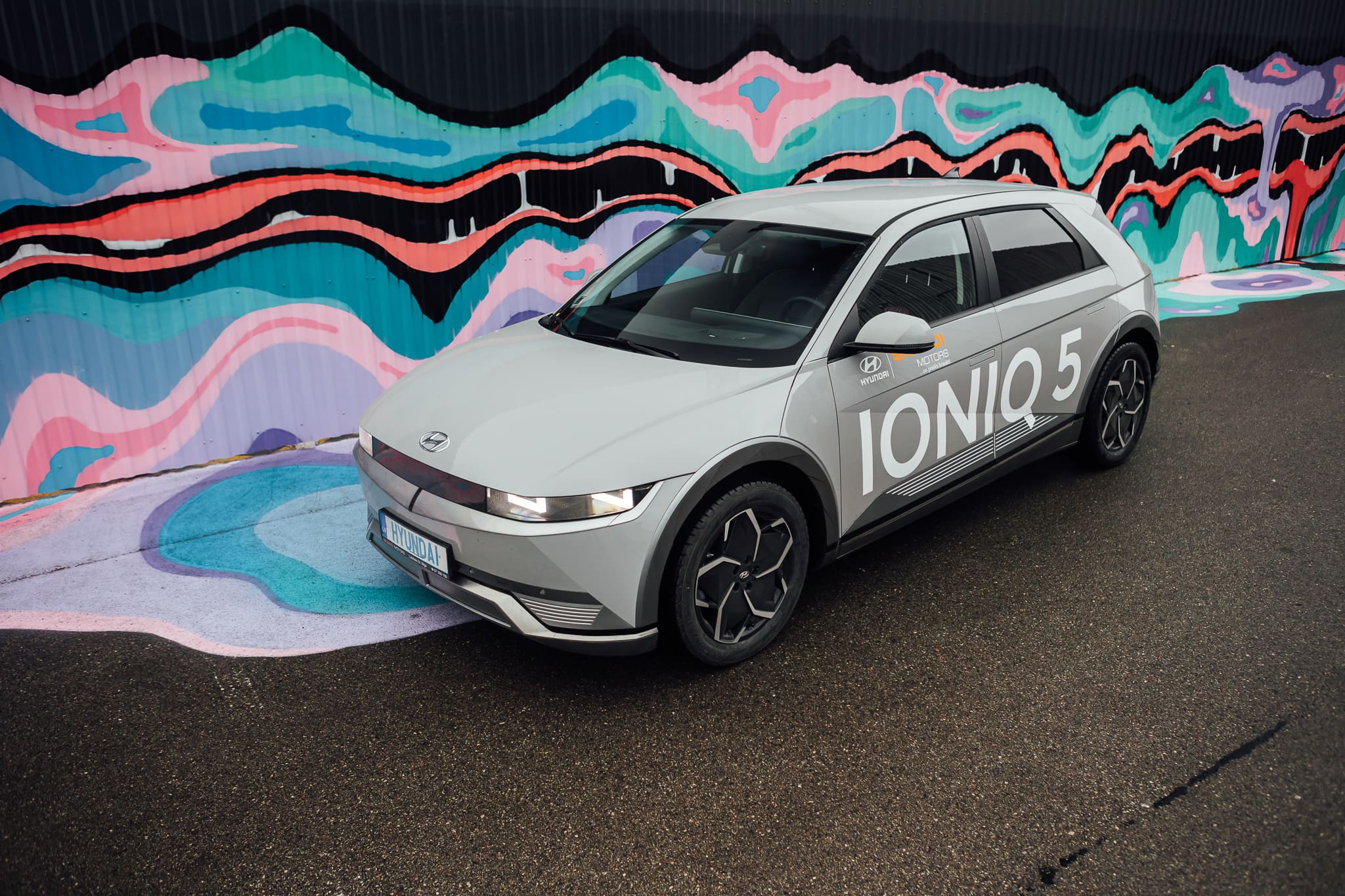 Hyndai Ioniq 5 pie krāsainas sienas